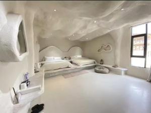 Shanyuhai Pure White Cave Sea View Holiday Hotel View Designer Hotel客房内的一张或多张床位
