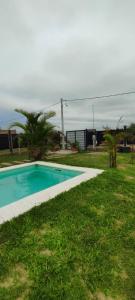 ein Swimmingpool im Gras neben einem Haus in der Unterkunft Casa Quinta Búho Norte in Resistencia