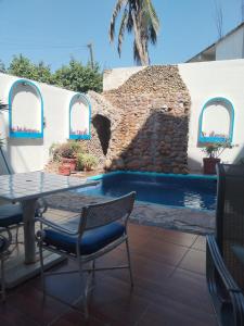 eine Terrasse mit Tisch und Stühlen und ein Swimmingpool in der Unterkunft LUUM hotel acapulco in Acapulco