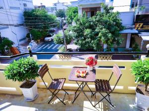 a table and chairs on a balcony with plants at Hotel Ngọc My in Phan Thiet +9 photos