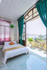 a bedroom with a bed and a large window at Hotel Ngọc My in Phan Thiet