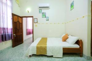 a bedroom with a bed with white sheets and an open door at Hotel Ngọc My in Phan Thiet