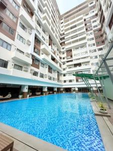 una grande piscina di fronte ad alcuni edifici di BE Residences Chic & Cozy a Cebu City
