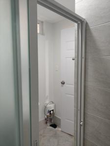 a bathroom with a white door and a toilet at Cozy condo unit at Amani Grand near Cebu Airport in Pusok
