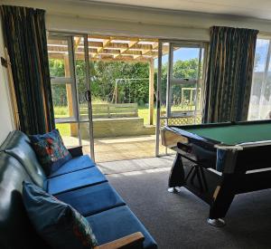 a living room with a pool table and a couch at Longford in Lower Kokatahi