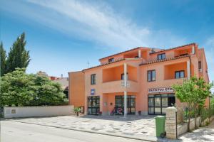 an orange building with a street in front of it at Holiday Home & Apartments Primavera in Pula
