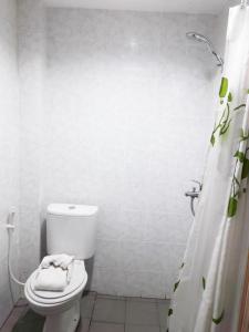 Baño blanco con aseo y cortina de ducha en Karimun City Hotel, en Tanjung Balai Karimun