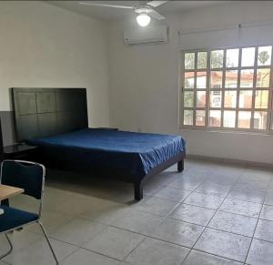 a bedroom with a bed and a table and a chair at Depas Anahuac in Monterrey