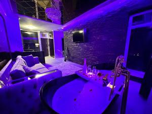 a purple room with a couch and a tub at Apartament Green Park in Iaşi