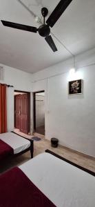 a bedroom with a bed and a ceiling fan at Holiday Apartments & Homestay in Sultan Bathery