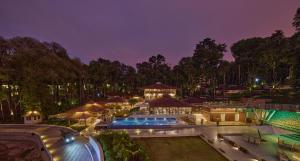 a mansion with a swimming pool at night at Regenta Resort Sakleshpur in Sakleshpur