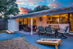 une maison avec un patio avec une table et des chaises dans l'établissement Jacuzzi & Pool House w/Game Room + Fire table, à The Colony