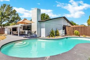 une piscine dans l'arrière-cour d'une maison dans l'établissement Jacuzzi & Pool House w/Game Room + Fire table, à The Colony