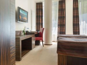 a hotel room with a bed and a desk at EA Hotel Crystal Palace in Prague