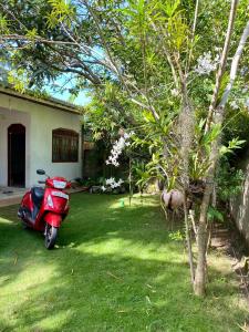 a red scooter parked in a yard next to a house at Villa Lee Polhena in Matara +13 photos