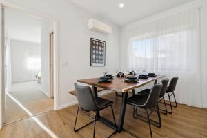 a dining room with a wooden table and chairs at The Crystal Palace 2 in Jindabyne +10 photos