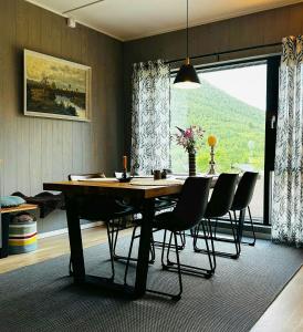 ein Esszimmer mit Tisch und Stühlen und einem Fenster in der Unterkunft Mountain Apartment With Views In Myrkdalen in Vossestrand