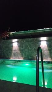 een zwembad 's nachts met een reling erin bij Casa BAMBU Club Simbal in Simbal