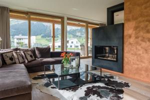 sala de estar con sofá y chimenea en Edelweiss Mountain Suites 04-01, en Flims