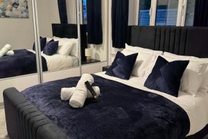 a bedroom with a large bed with two mirrors at Spacious Bungalow - Hot Tub, Garden, Gated Parking in Dudley