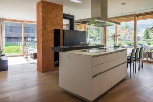 a kitchen with a white island with a stove at Edelweiss Mountain Suites 04-01 in Flims