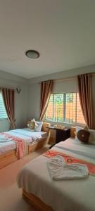 a bedroom with two beds and a window at Sok San Boutique and Spa in Siem Reap