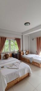 a bedroom with two beds and a window at Sok San Boutique and Spa in Siem Reap