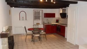 a kitchen with red cabinets and a table and chairs at Les Calaubys in Huriel