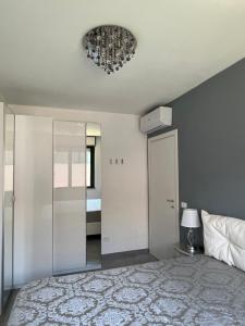 a bedroom with a bed and a chandelier on the ceiling at Maison Belle Montenero Marina in Marina di Montenero