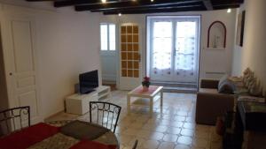 a living room with a couch and a tv at Les Calaubys in Huriel