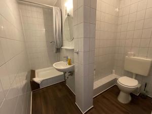 a white bathroom with a toilet and a sink at Pension Markt Neustrelitz in Neustrelitz +29 photos