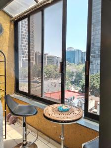 einem Tisch mit einem Kuchen vor einem Fenster in der Unterkunft Suite Reforma Ahuehuete in Mexiko-Stadt