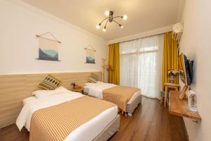 a hotel room with two beds and a television at 悦隐客栈 in Yangshuo +11 photos