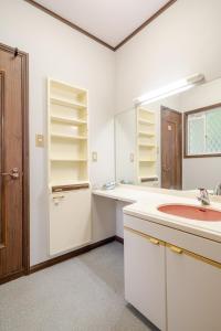 a white bathroom with a sink and a mirror at 富士見テラス山中湖マイペンライ in Yamanakako