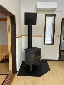 a black stove in a room with a window at 富士見テラス山中湖マイペンライ in Yamanakako