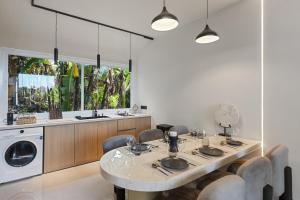 ケロボカンにあるNew 2BR Architectural Masterpiece in Umalasのキッチン(テーブル、洗濯機付)