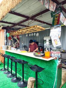 a person preparing food at a counter in a restaurant at 復古車露營住宿 in Hong Kong