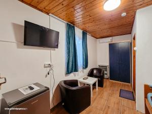 a room with a tv and a chair and a table at Summer Vibe Costinesti in Costinesti