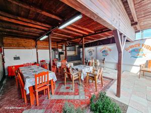 a restaurant with tables and chairs on a patio at Summer Vibe Costinesti in Costinesti