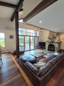 Adventure Bay布鲁尼岛冒险湾度假酒店的客厅设有真皮沙发和石制壁炉