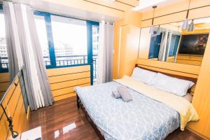 a bedroom with a bed and a large window at Metro Paradise 1BR Comfort Makati swim gym park 300MB 2320 in Manila +50 photos