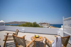 a balcony with a table and chairs and a view of the ocean at Mykonos Windmills View in Megali Ammos
