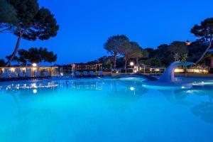 a swimming pool at night with a water slide at Hôtel Vacances Bleues Delcloy in Saint-Jean-Cap-Ferrat