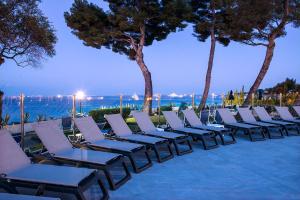 a row of lounge chairs on the beach at night at Hôtel Vacances Bleues Delcloy in Saint-Jean-Cap-Ferrat