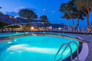 a swimming pool in a resort at night at Hôtel Vacances Bleues Delcloy in Saint-Jean-Cap-Ferrat