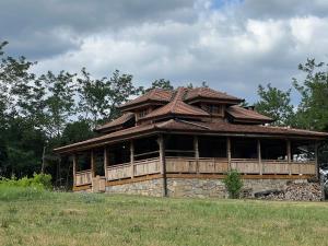 a large building with a roof on a field at Brvnara "Duboki Potok" in Vrnjačka Banja
