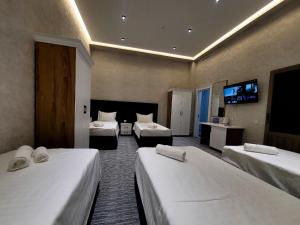 a hotel room with two beds and a flat screen tv at MIRON Hotel in Samarkand