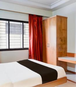 a bedroom with a white bed and a red curtain at Hotel comfort stay in Bengaluru