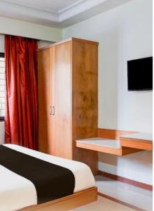 a bedroom with a bed and a wooden cabinet at Hotel comfort stay in Bengaluru