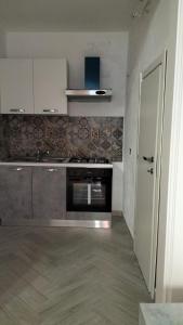 a kitchen with a stainless steel stove and a door at Casa vacanze Don Fefè in Ispica